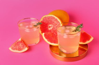 Renkli arkaplanda bir bardak lezzetli greyfurt limonatası.