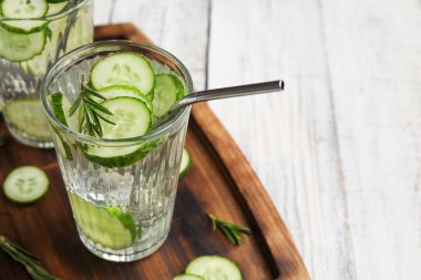 Hafif ahşap arka planda salatalıklı limonata.