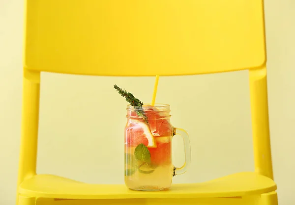 Einmachglas Mit Leckerer Grapefruit Limonade Auf Stuhl Vor Farbigem Hintergrund — Stockfoto