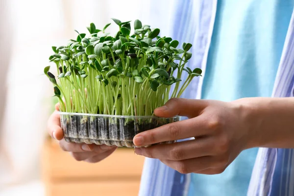 Woman with fresh micro green at home
