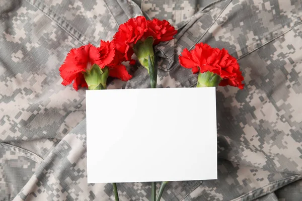 軍事制服と空の紙シートを持つ新鮮なカーネーションの花 — ストック写真