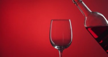 Kadın renk arka planına şarap dolduruyor.