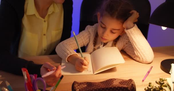 一个女人在深夜帮助她的小女儿做家庭作业 — 图库视频影像