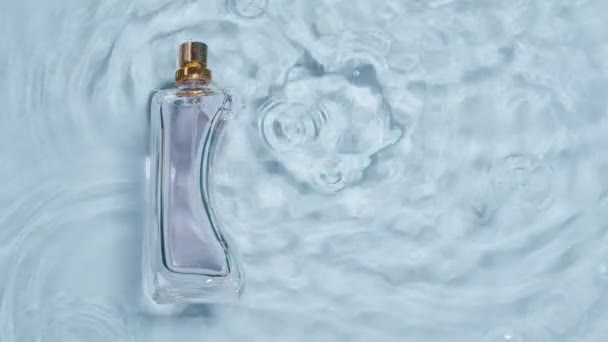 Bouteille Parfum Dans Eau Sur Fond Clair Vue Dessus — Video