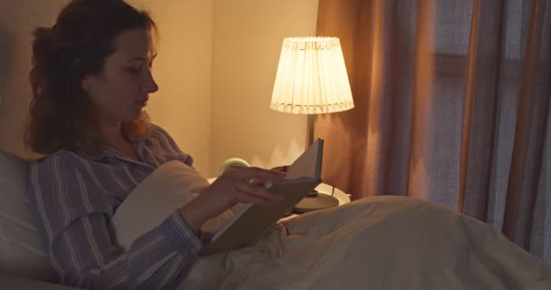 Mujer Joven Lee Libro Pone Máscara Del Sueño Cama — Vídeos de Stock