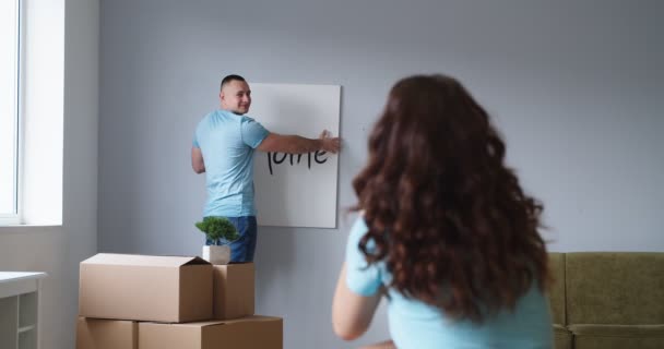 Ungt Par Hængende Billede Væggen Deres Nye Lejlighed – Stock-video