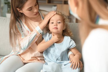 Pediyatrist küçük kızı evde muayene ediyor.