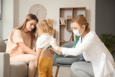 Pediyatrist küçük kızı evde muayene ediyor.