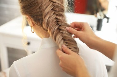 Kuaför müşteriyle güzellik salonunda çalışıyor.