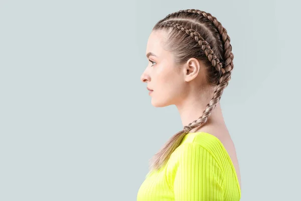 Hermosa Joven Con Cabello Trenzado Sobre Fondo Gris —  Fotos de Stock