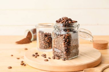 Kahve çekirdekli kavanoz ve ahşap arka plan.