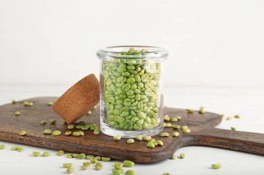 Açık fonda yeşil kahve çekirdekleri olan kavanoz.