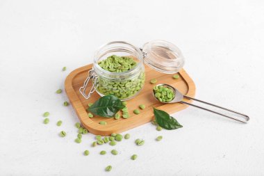 Kavanoz ve kaşık, arka planda yeşil kahve çekirdekleri.