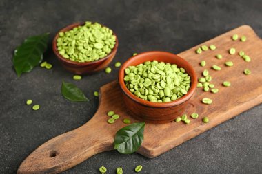 Koyu fonda yeşil kahve çekirdekleri olan kaseler.