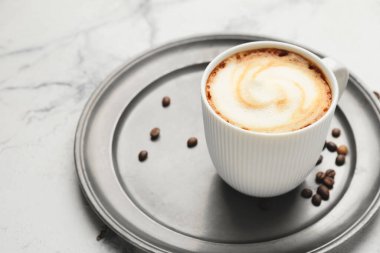 Hafif arka planda bir fincan sıcak kapuçino.