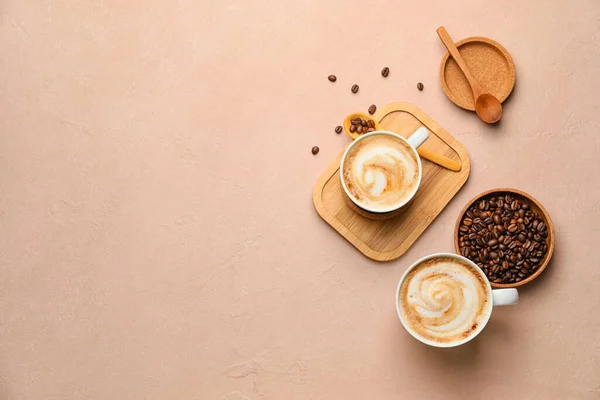 Tassen Heißen Cappuccino Und Teller Mit Kaffeebohnen Auf Farbigem Hintergrund — Stockfoto