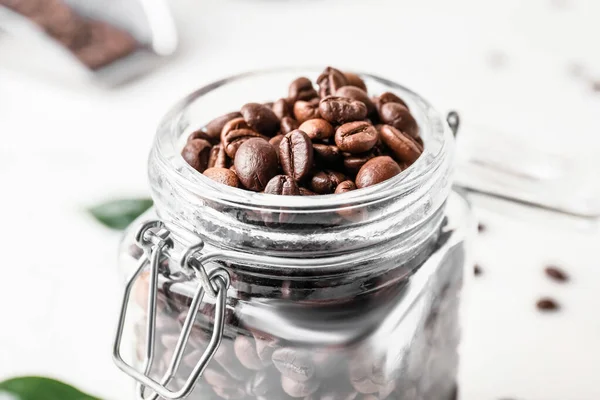 光を背景にコーヒー豆とジャー クローズアップ — ストック写真