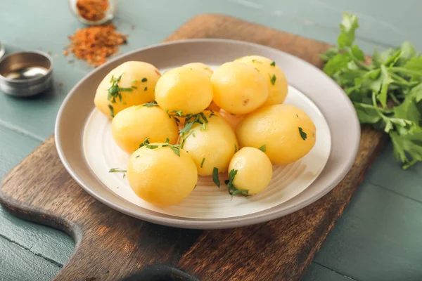 Teller Mit Leckeren Gekochten Kartoffeln Mit Petersilie Auf Farbigem Holzhintergrund — Stockfoto