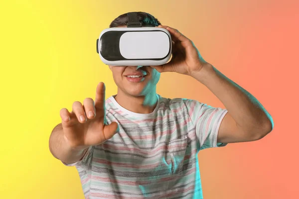 Junger Mann Mit Virtual Reality Brille Auf Farbigem Hintergrund — Stockfoto