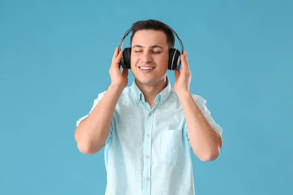 一个年轻英俊的男人 带着耳机 在彩色背景下听音乐 — 图库照片