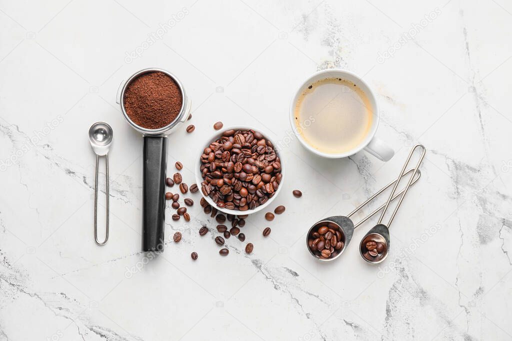 Composition with cup of coffee, beans and powder on light background