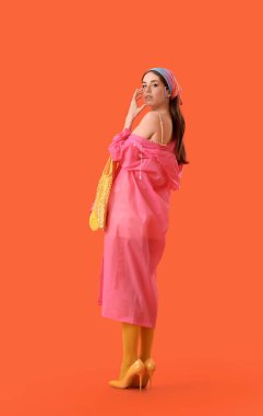 Renkli arka planda maske takan şık bir genç kadın.