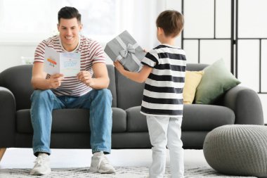 Babalar Günü 'nde evde babasını selamlayan küçük bir çocuk.