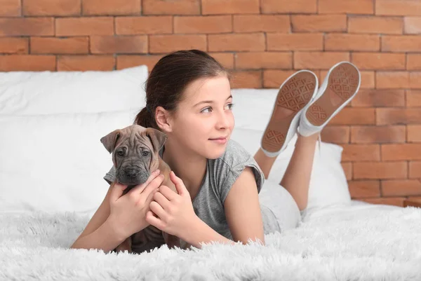 可爱的女孩带着小狗躺在家里的床上 — 图库照片