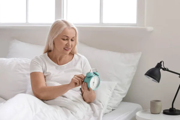 Mature Woman Setting Alarm Clock Bedroom — Stock Photo, Image