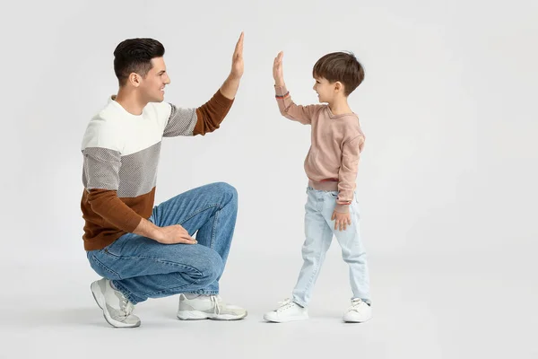 Boldog Apa Kisfia Pacsit Adnak Egymásnak Könnyű Háttérrel — Stock Fotó