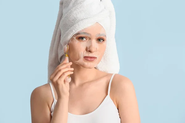 Mooie Jonge Vrouw Met Blad Gezichtsmasker Massage Tool Kleur Achtergrond — Stockfoto