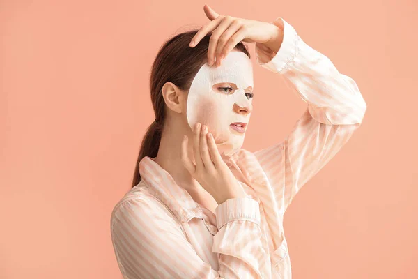 Schöne Junge Frau Mit Blatt Gesichtsmaske Auf Farbigem Hintergrund — Stockfoto