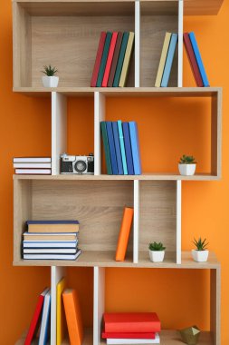 Renk arkaplan üzerine kitap ve dekor içeren raf birimi