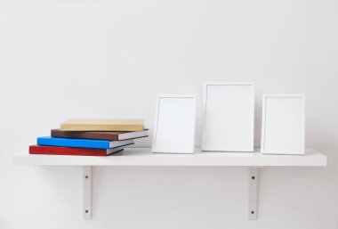 Kitaplı raflar ve açık arkaplanda boş çerçeveler