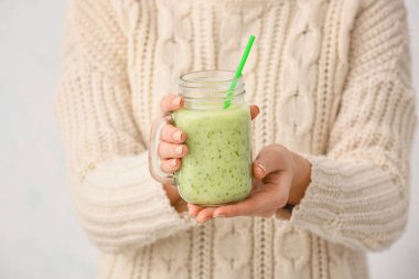 Arka planda meyve suyu kavanozu olan bir kadın.