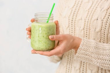 Arka planda meyve suyu kavanozu olan bir kadın.