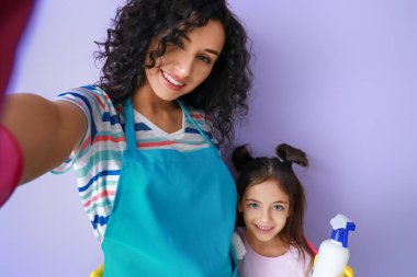 Anne ve kızı, arka planda selfie çekiyorlar.