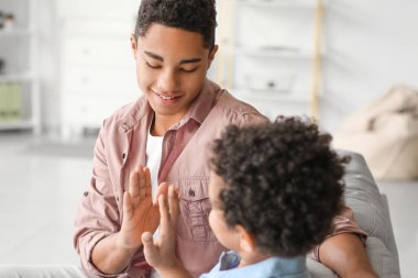 Afro-Amerikalı çocuklar evde birbirlerine beşlik çakıyorlar.