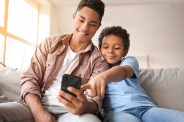 Odada cep telefonu kullanan Afro-Amerikalı çocuklar