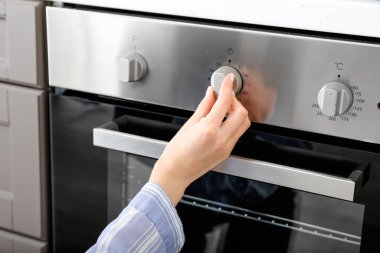 Mutfakta fırını ayarlayan kadın.