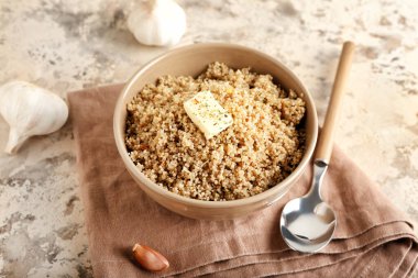 Lezzetli kinoalı kase, arkaplanda tereyağı ve sarımsak.