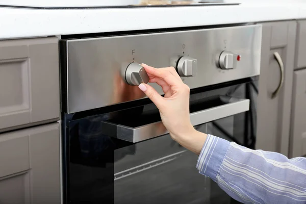 Wanita Menyesuaikan Oven Dapur — Stok Foto