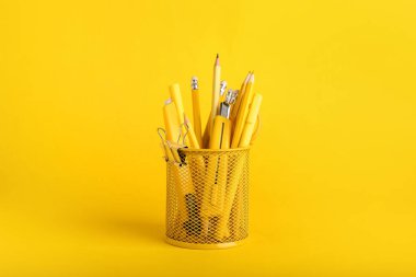 Renk arkaplanı üzerinde farklı kırtasiye malzemesi olan tutucu