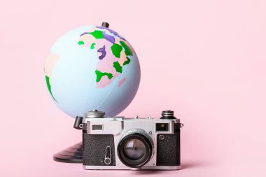 Renk arkaplanında küre olan fotoğraf makinesi