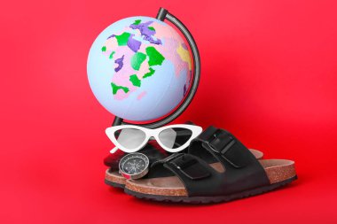 Renk arkaplanında pusula ve plaj aksesuarları olan dünya