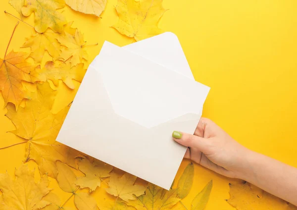 Vrouwelijke Hand Met Envelop Blanco Kaart Herfstbladeren Kleur Achtergrond — Stockfoto