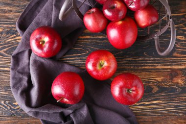 Tahta zemin üzerinde taze kırmızı elmalar olan sepet.