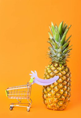 Arka planda alışveriş arabası olan komik ananas.