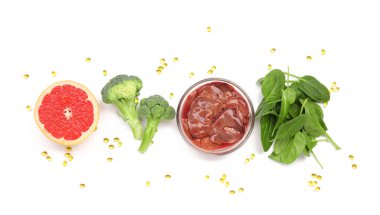 Beyaz arka planda hapları olan sağlıklı ürünler.