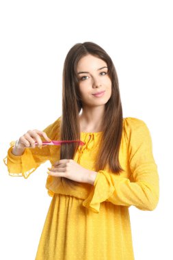 Beyaz arka planda saç tarağı olan güzel genç bir kadın.